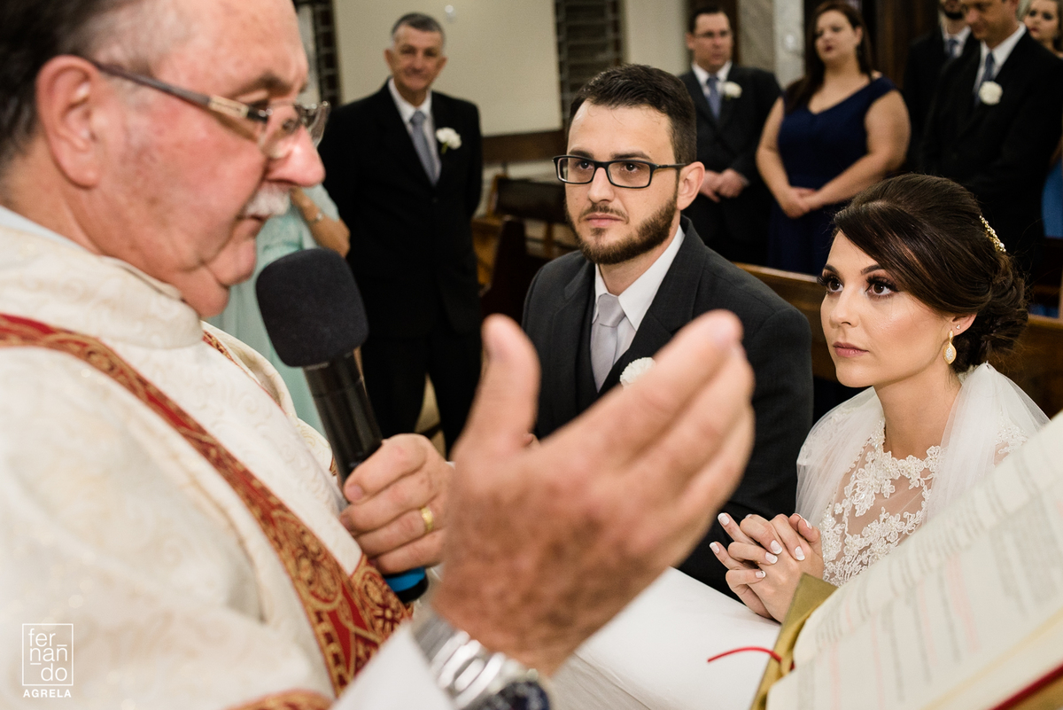 noivos e padre durante a cerimonia religiosa