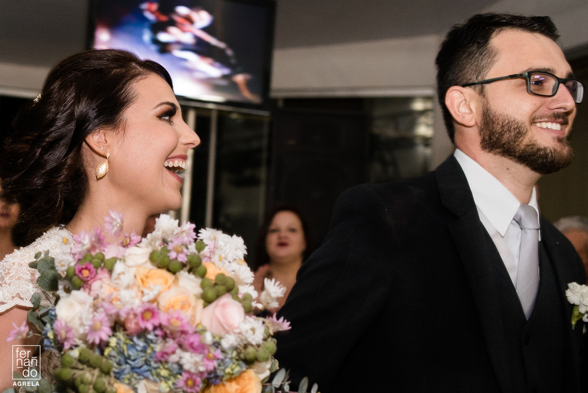 noivos sorrindo durante a entrada na festa