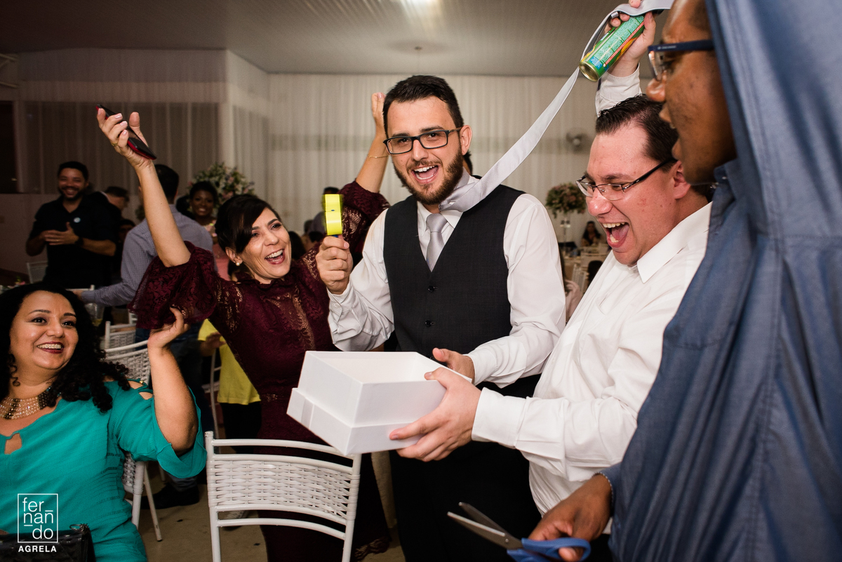 noivo passando a gravata com os amigos