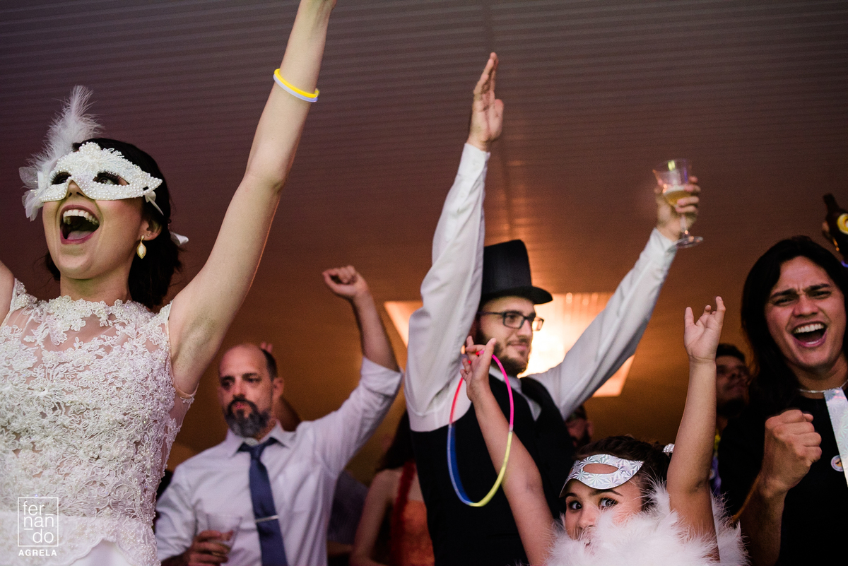 noivos e convidados sorrindo e dançando durante a festa de casamento