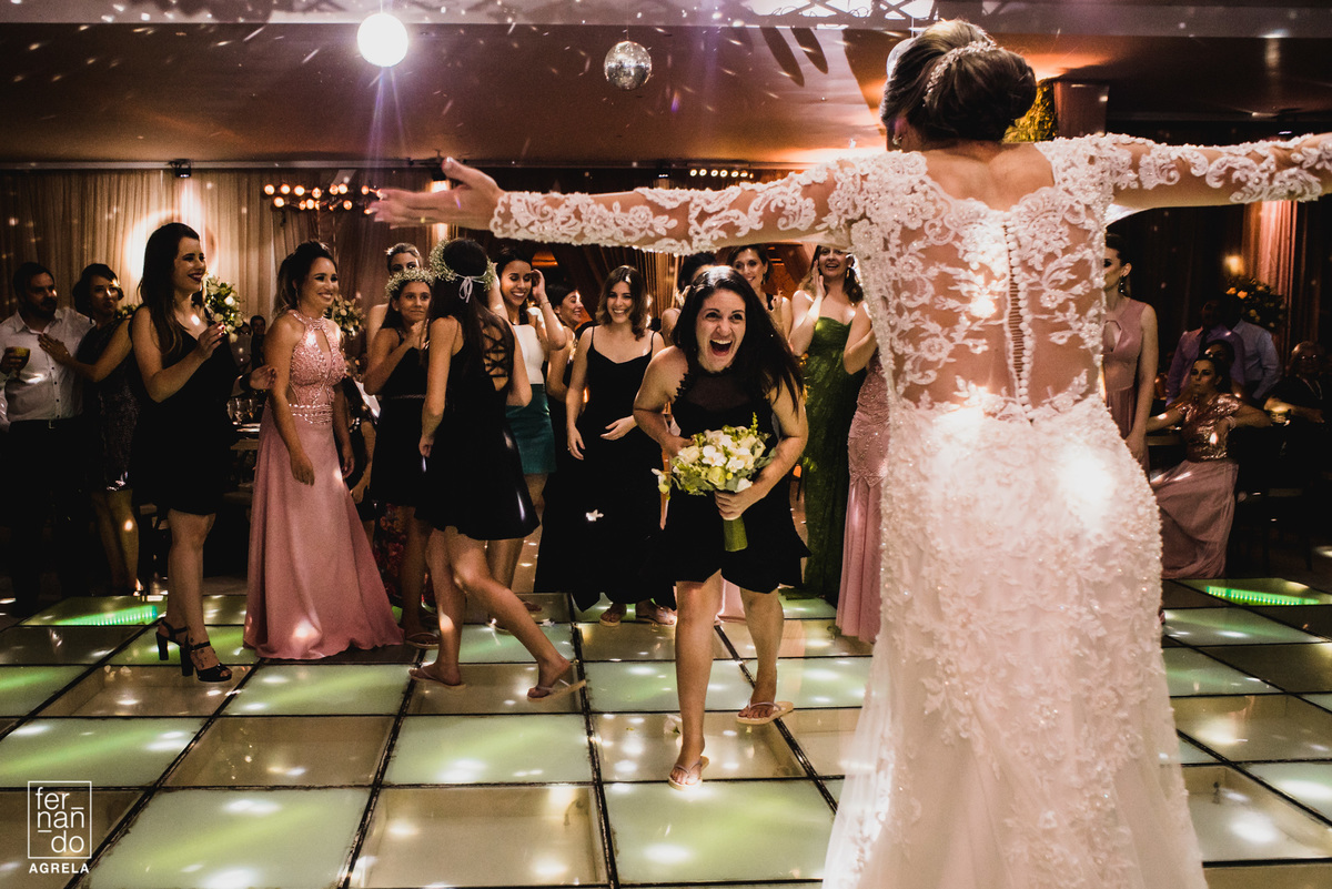 solteira que pegou o bouquet da noiva indo abraçar ela