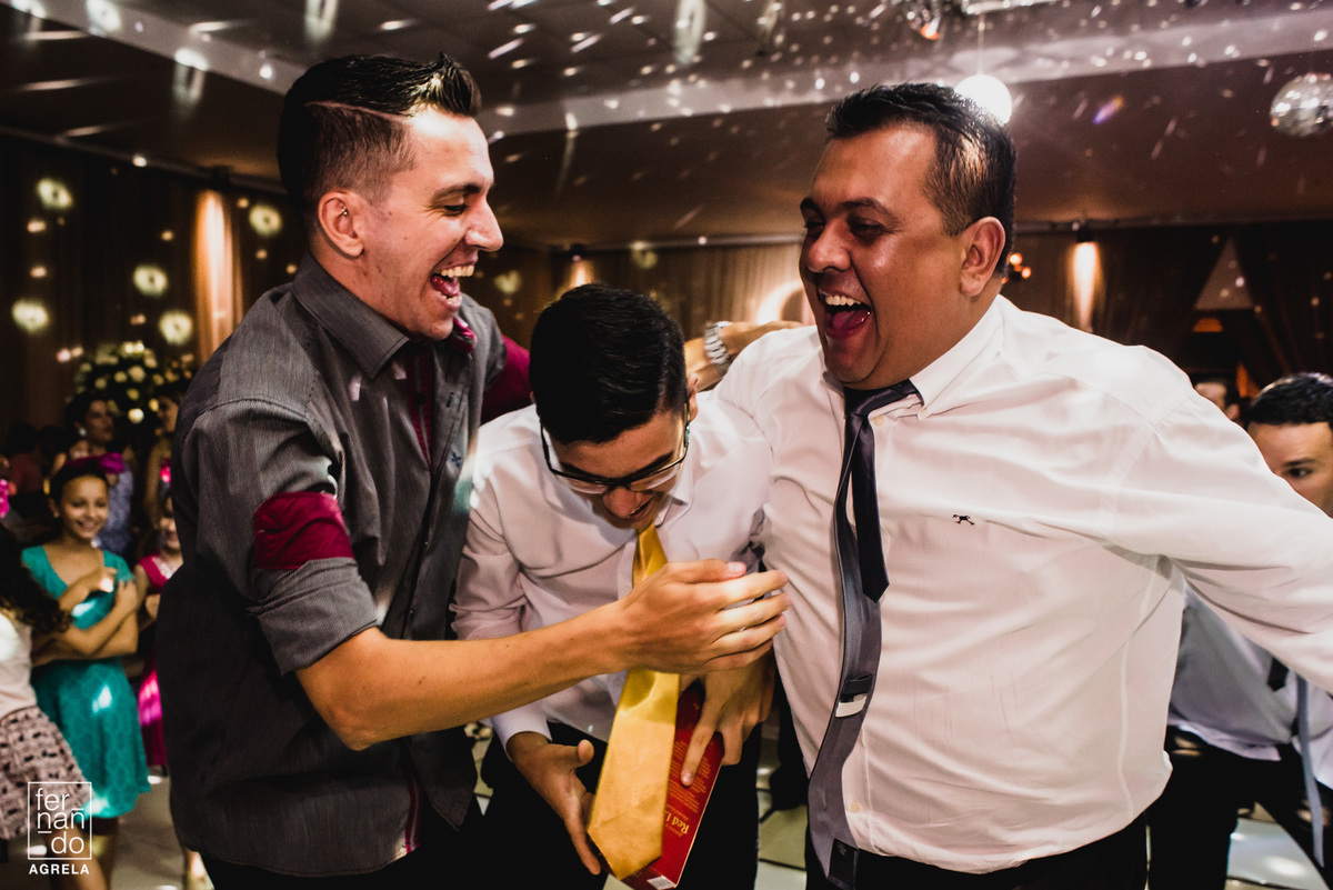 outros convidados comemorando que o amigo conseguiu pegar a garrafa de wisk do noivos