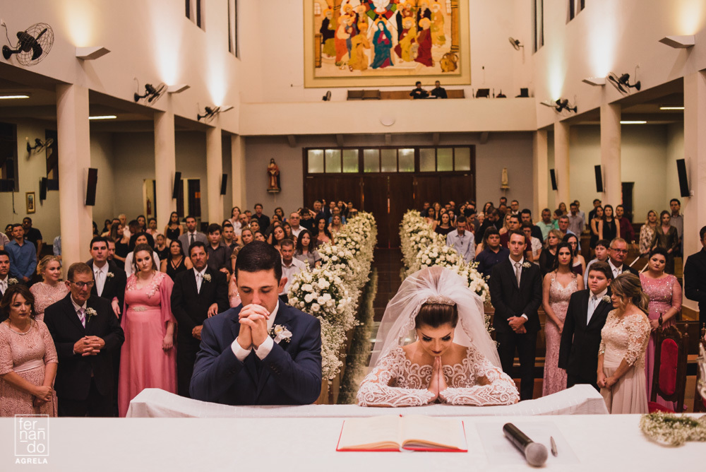 noivos após comungarem durante o casamento rezando