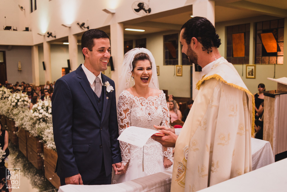 noivos sorrindo com o padre na igreja matriz de manduri