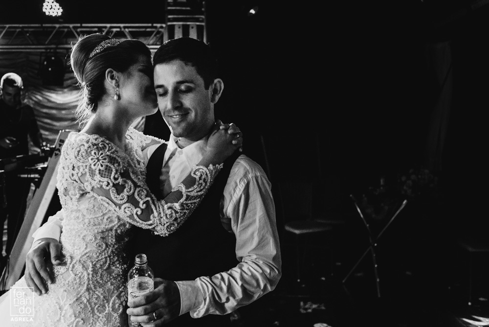 noiva beijando noivo no rosto durante a festa de casamento