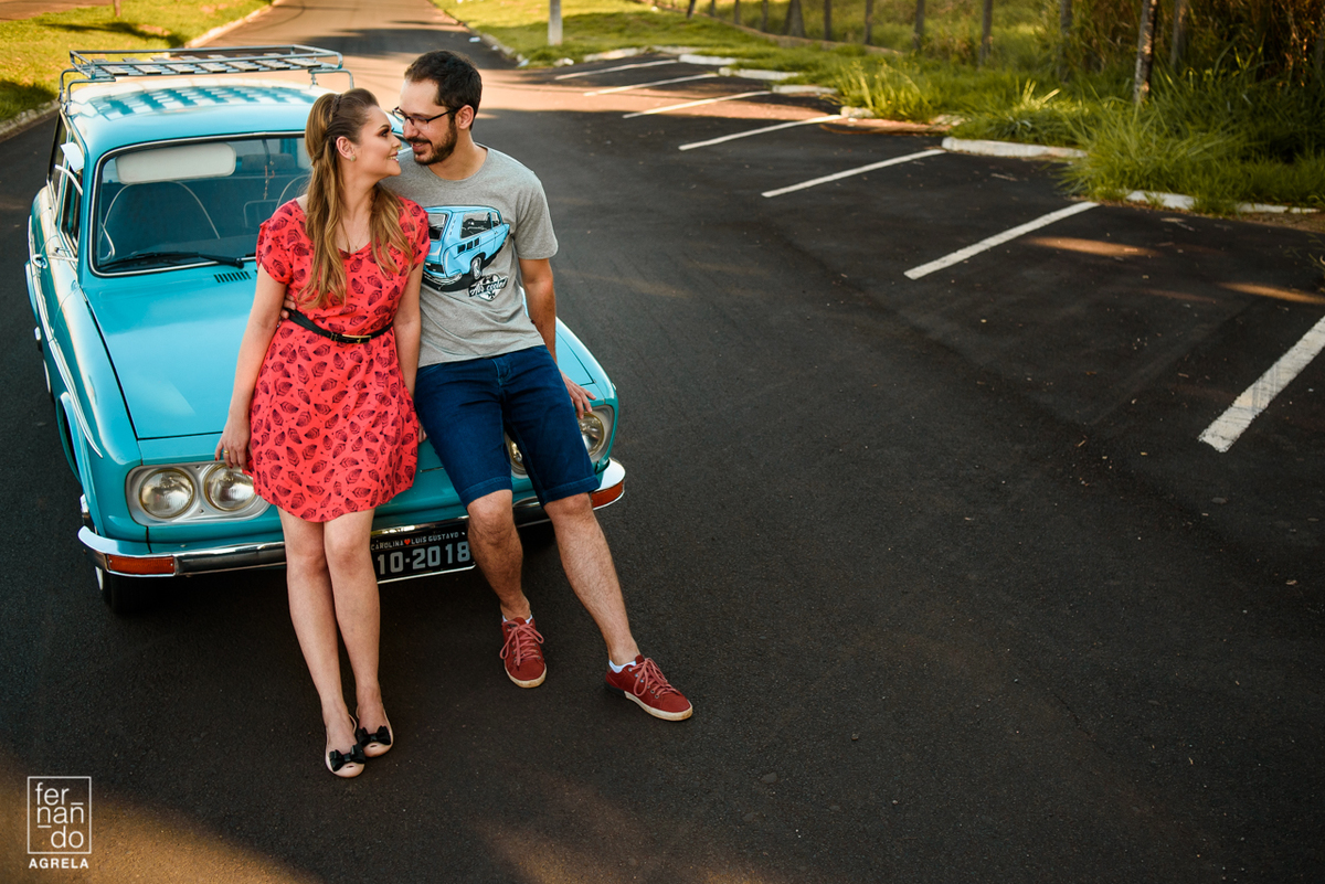 casal sorrindo sentado no carro caravan do noivo