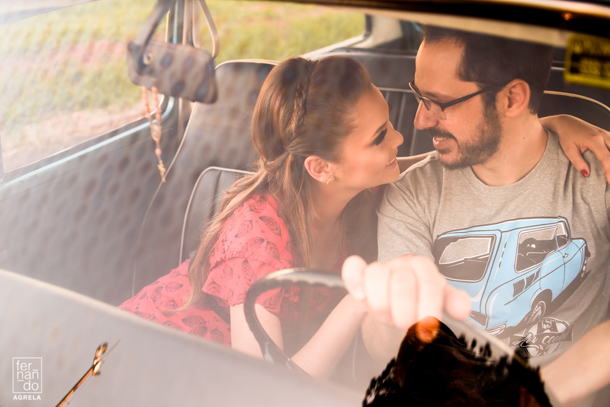 casal se olhando atravez de um vidro do carro caravan do noivo