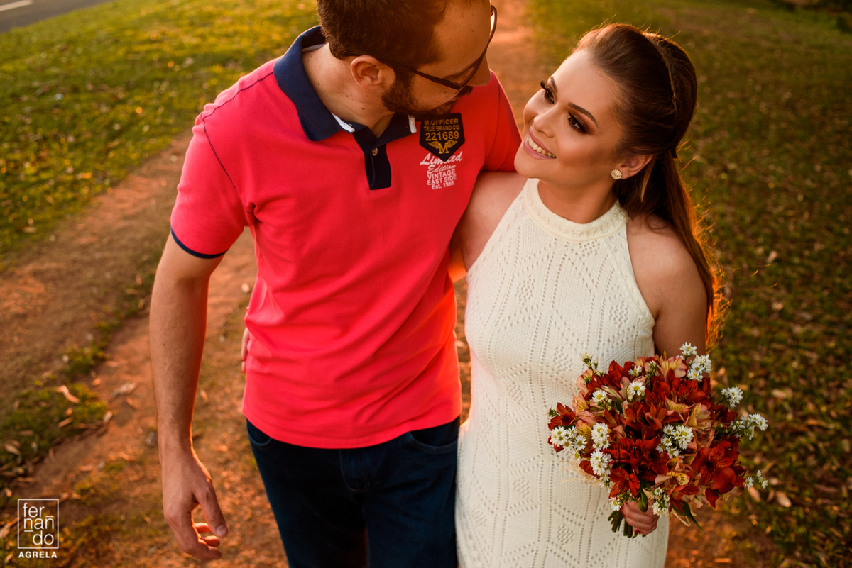 casal de noivos caminhando juntos em estrada de terra durante o por do sol