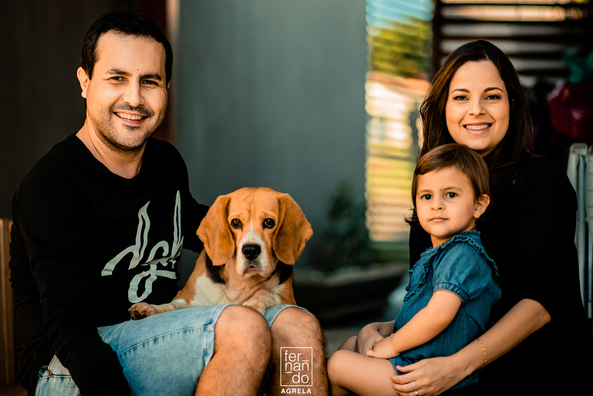 familia com mae gestante pai filha mais nova e um cachorro beagle durante ensaio de familia