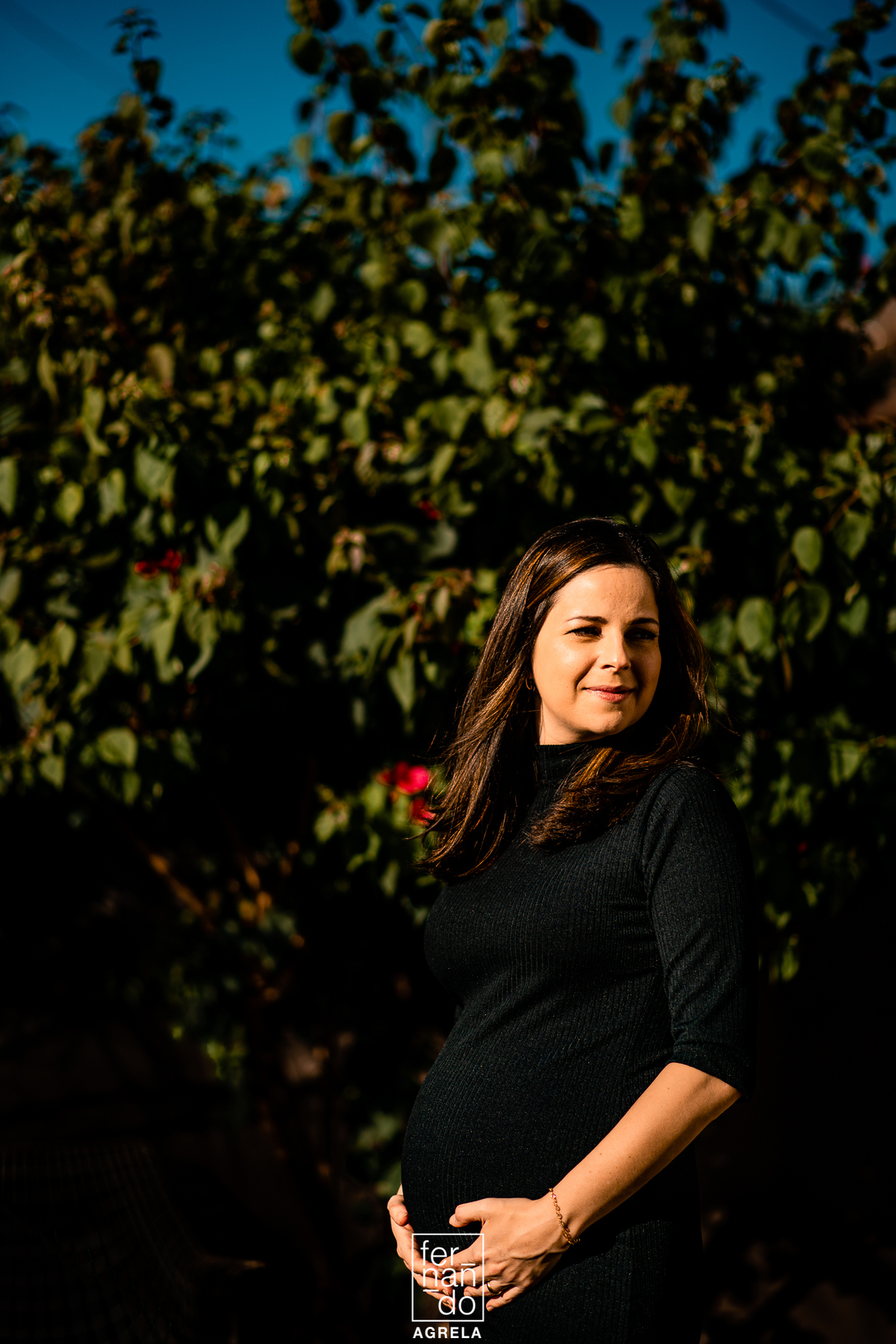 gestante com arvores de fundo no fim de tarde