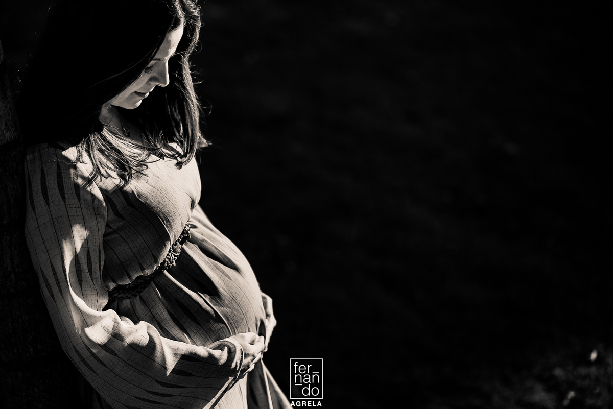 gestante segurando abarriga no fimd e tarde turante o ensaio