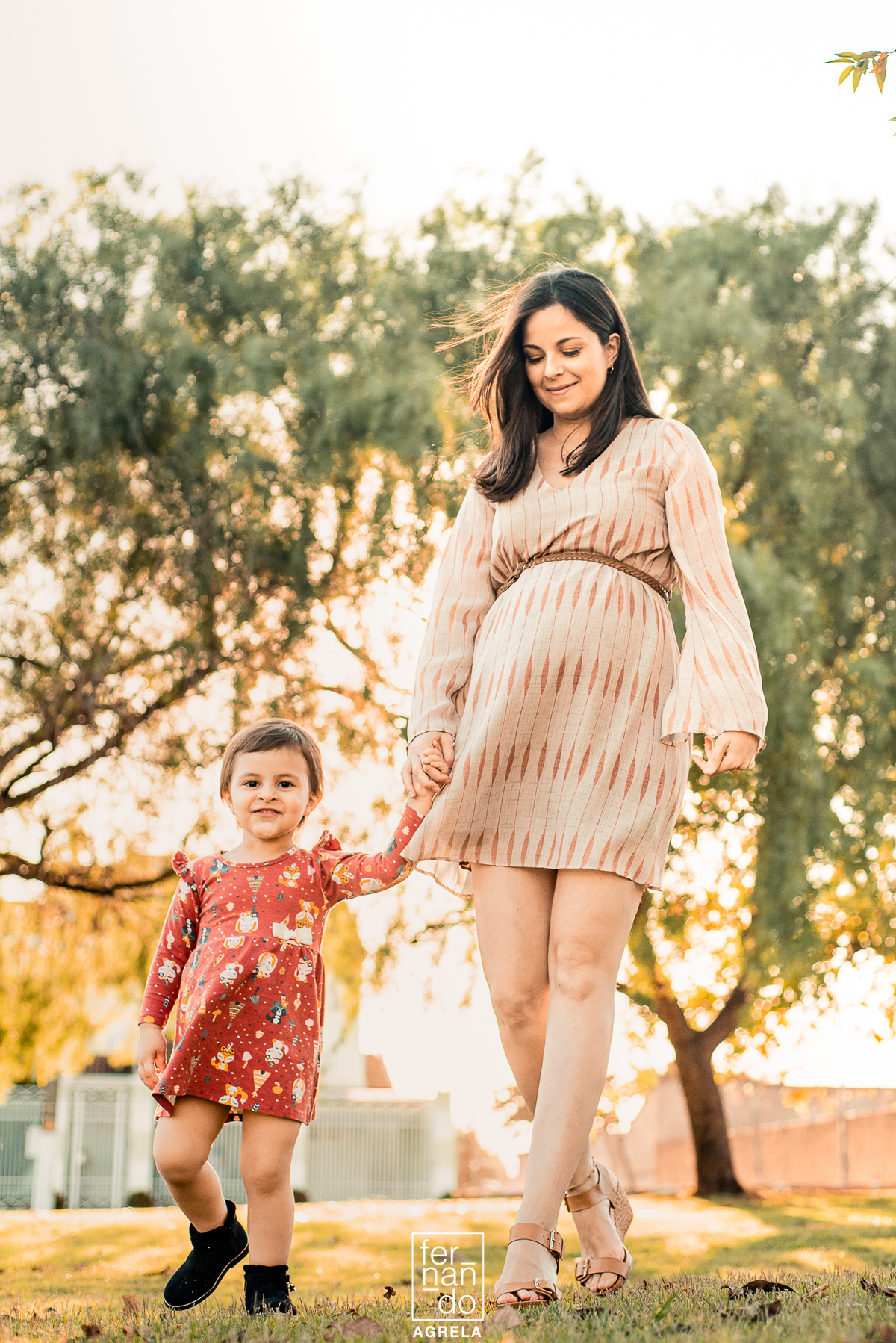 mae em gestação andando com filha mais nova de maos dadas