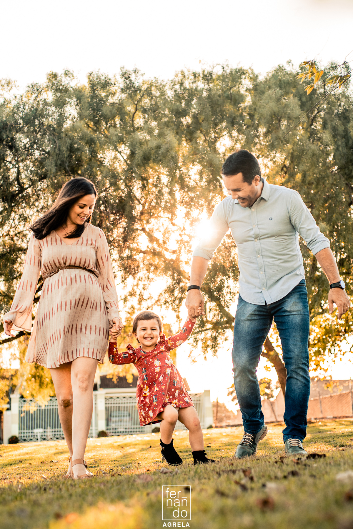 pai e mae caminhando com a criança mais nova durante ensaio de gestação