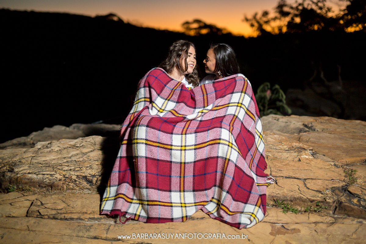 CASAL ACONCHEGANDO COM COBERTOR NO PÔR DO SOL NA SERRA DO CIPO, MINAS GERIAS, ENSAIO HOMOAFETIVO
