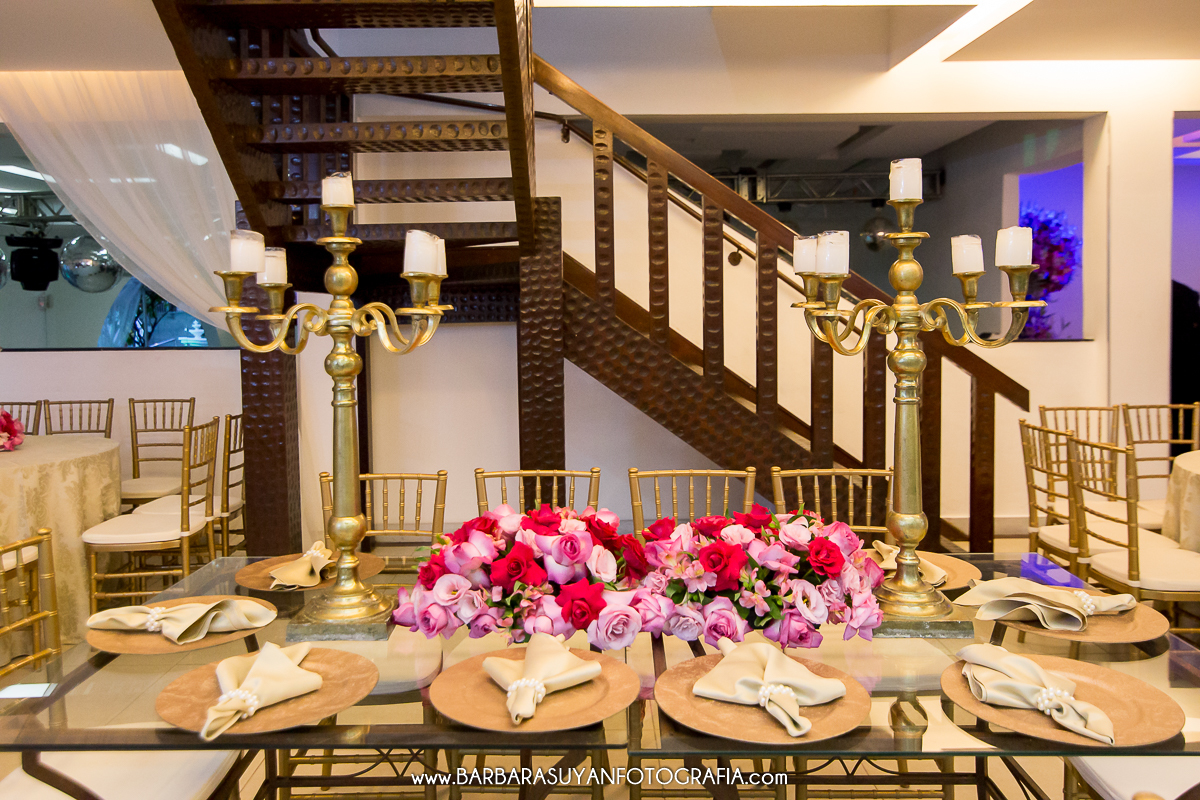 Mesa dos pais com castiçais dourados e guardanapos bege com pérolas. Decoração da recepção de casamento de Lívia e Thiago no Chalé Pampulha. Decoração com rosas e flores naturais, cadeiras douradas e toalhas brancas