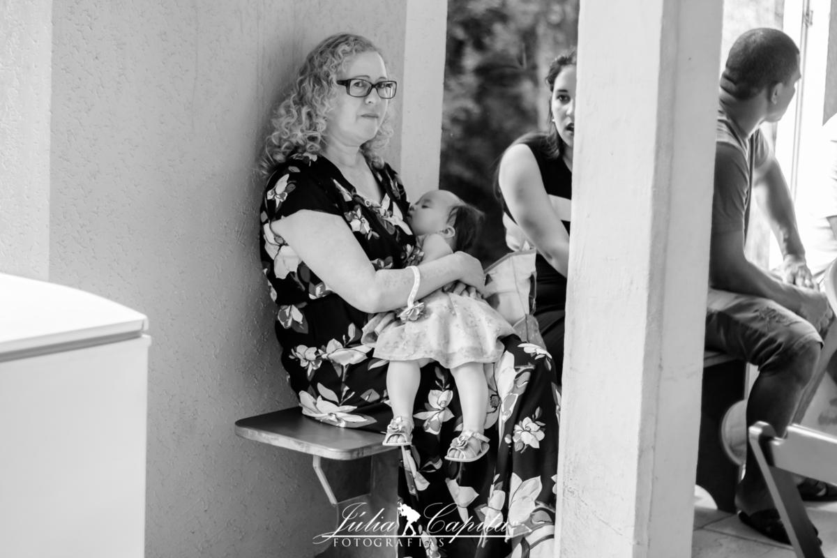 Avó segurando a neta durante sua festa de aniversário no Clube da Alcoa em Poços de Caldas