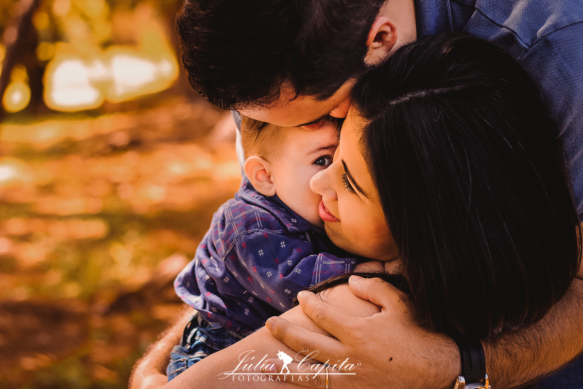 Pai, mãe e filho se abraçando durante ensaio fotográfico em Poços de Caldas