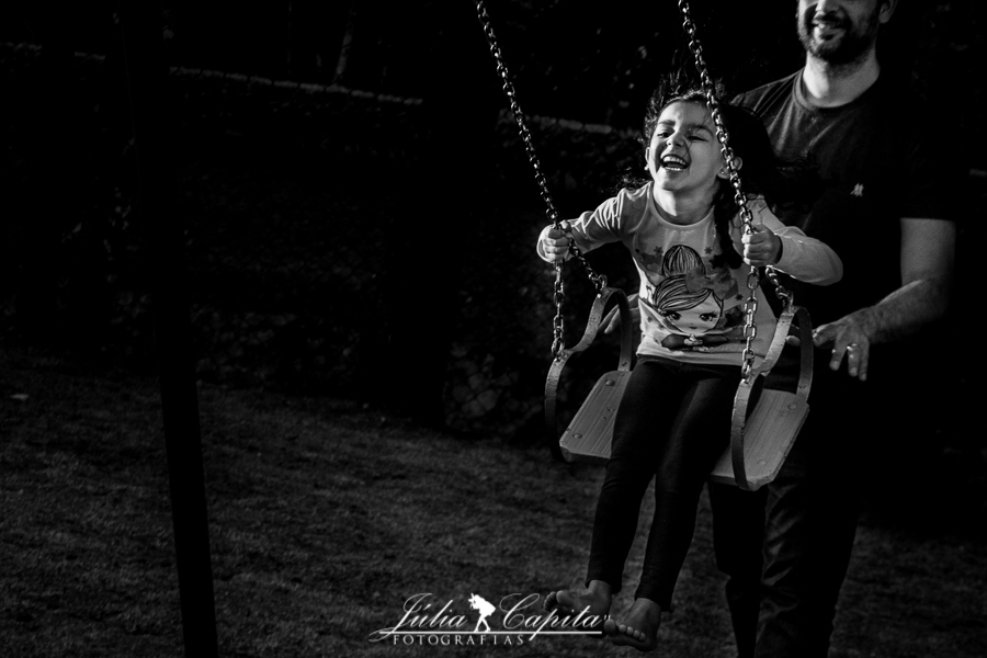 Pai empurrando a filha no balanço em ensaio fotográfico infantil