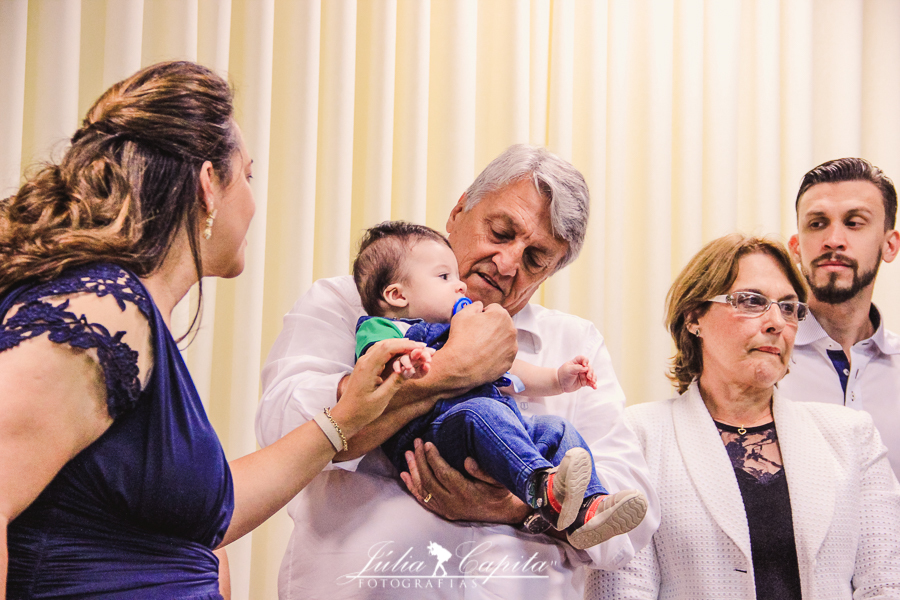 Bebê no colo do pai na sua consagração por Júlia Capita Fotografias