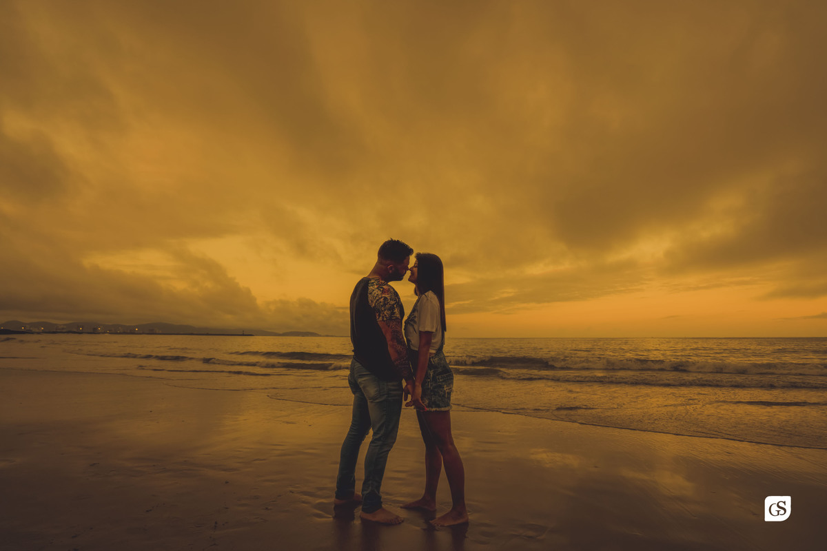 ensaio fotográfico de noivos na praia se beijando no por do sol de Itajai SC