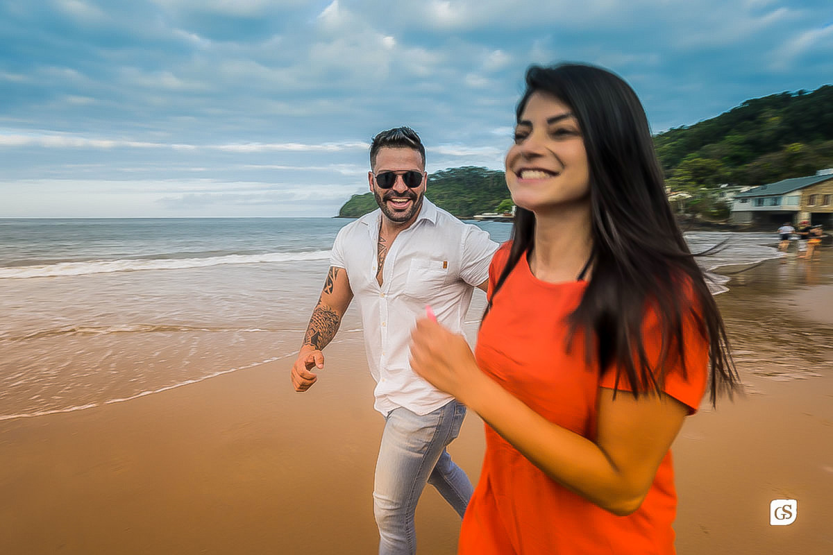 ensaio fotográfico de noivos correndo na praia de Itajai SC