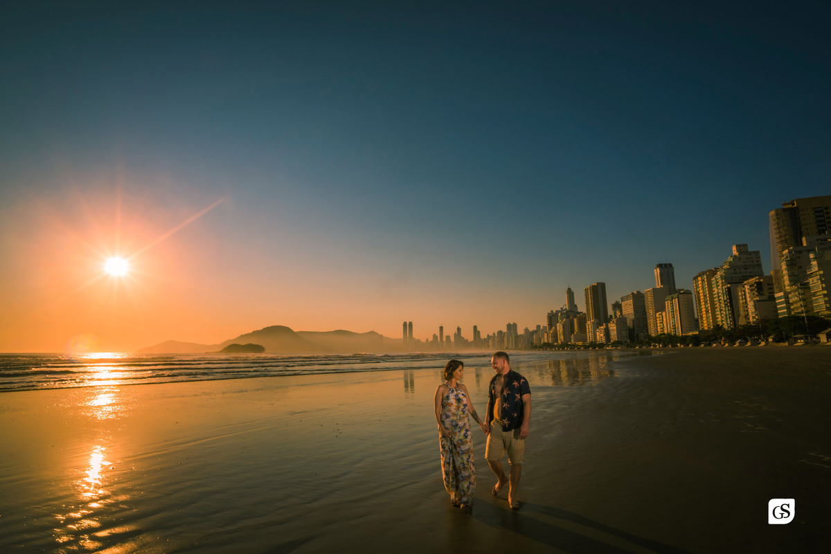 ensaio fotográfico de casal noivos andando  na praia de balneário camboriú SC