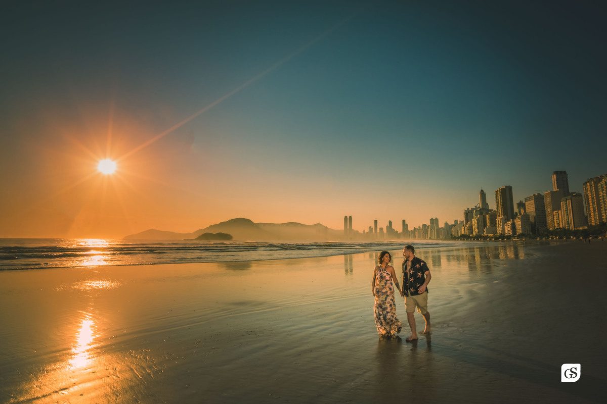 ensaio fotográfico de casal noivos correndo na praia de balneário camboriú SC