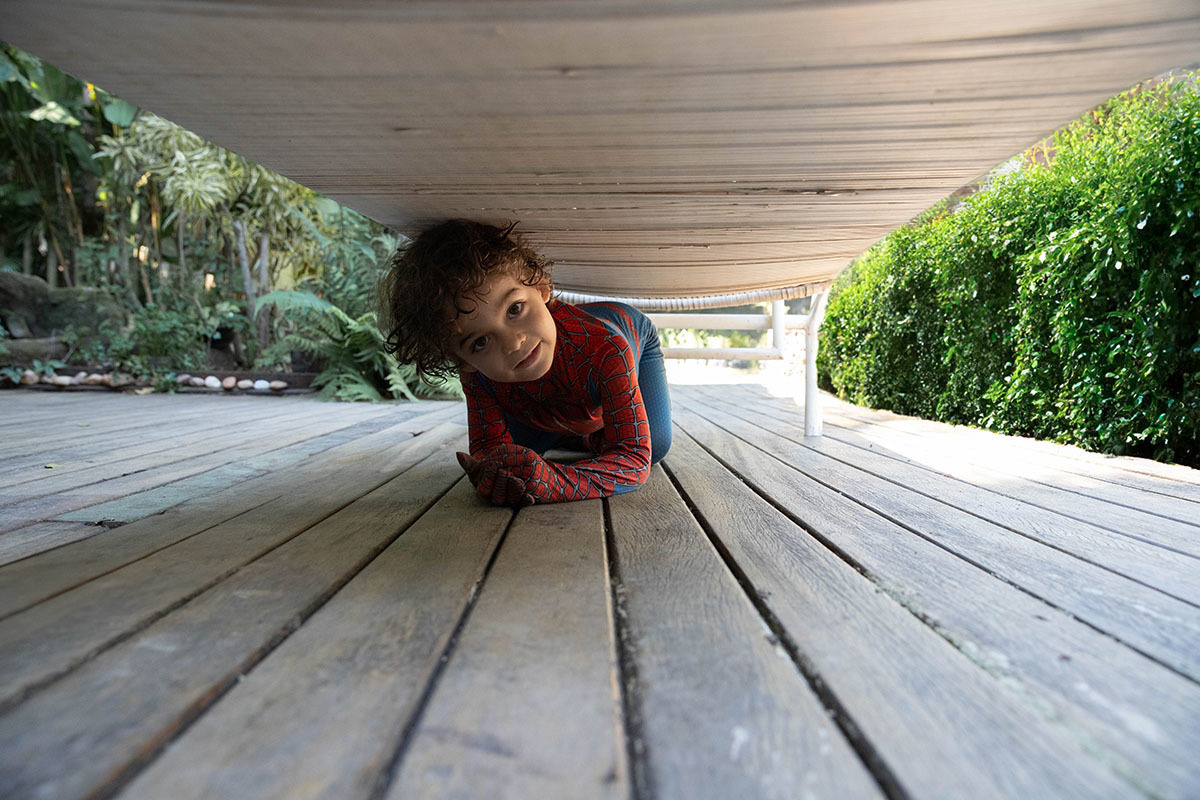 João embaixo da espreguiçadeira durante ensaio de gestante no Rio de Janeiro.