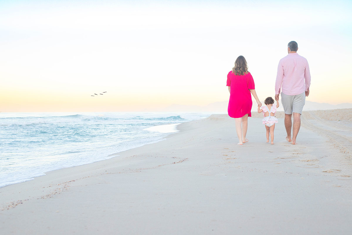 Ensaio gestante na Praia da Barra com a família caminhando na areia, Rio de Janeiro