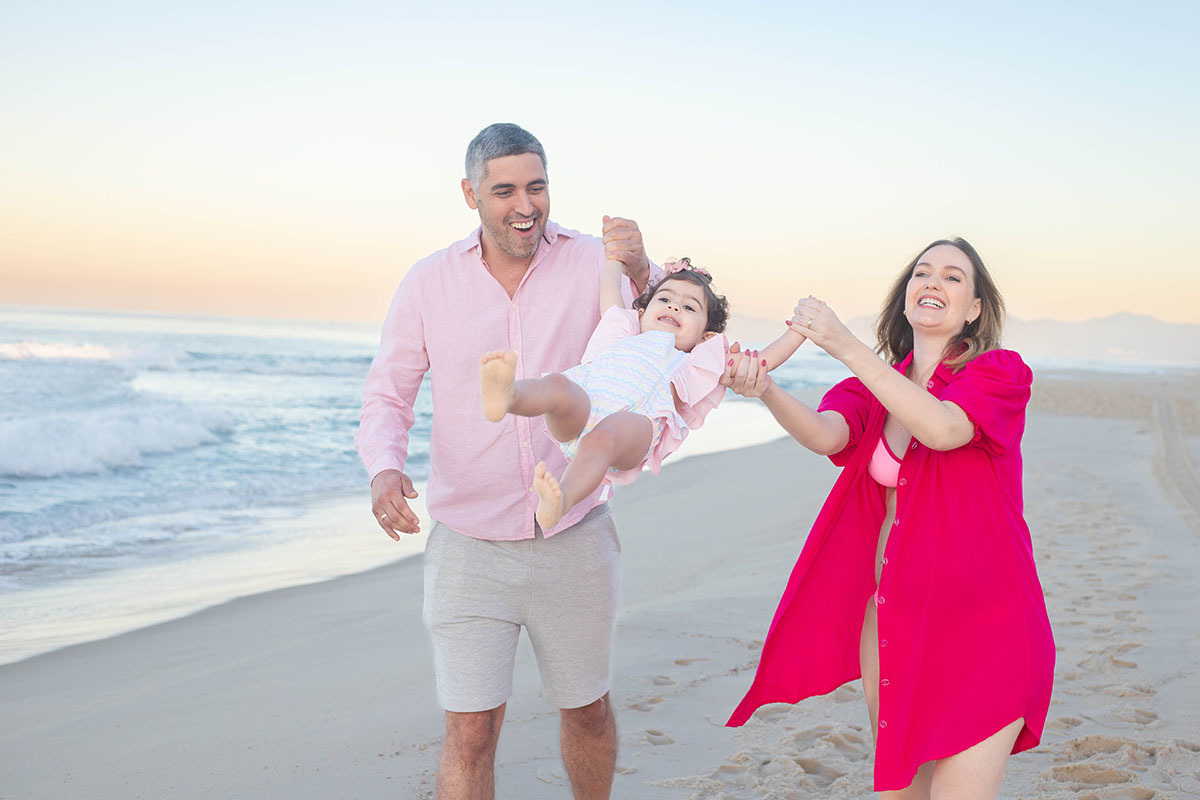 Ensaio gestante com a filha correndo na areia da praia da Barra no Rio