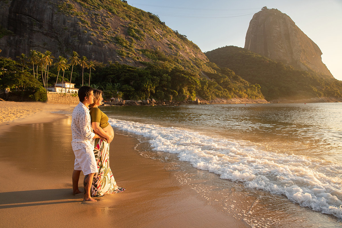 gestante e marido abraçados na Praia Vermelha, Urca, ao amanhecer - Ensaio de gestante no Rio de Janeiro.