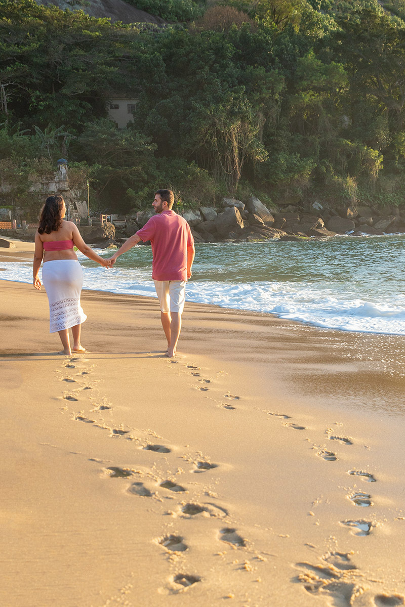 Casal caminhando na beira do mar em ensaio gestante na Urca.