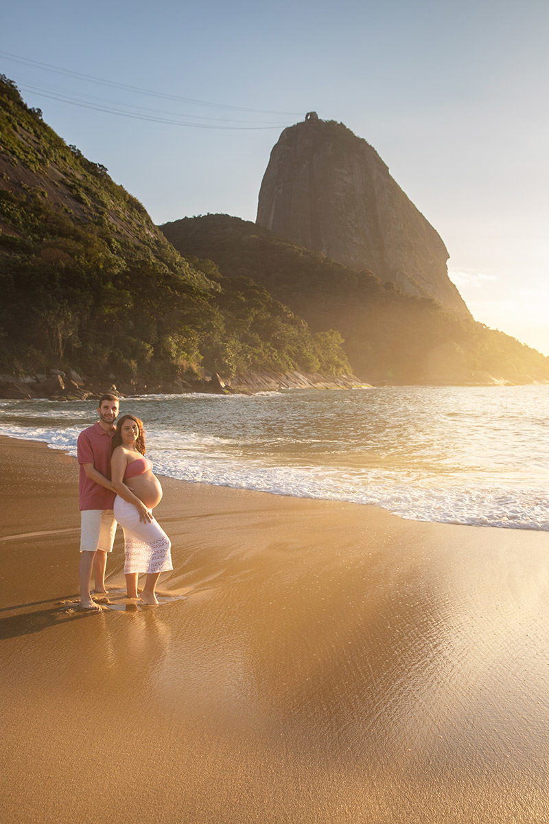 Casal abraçado durante ensaio de gestante na Praia Vermelha RJ.