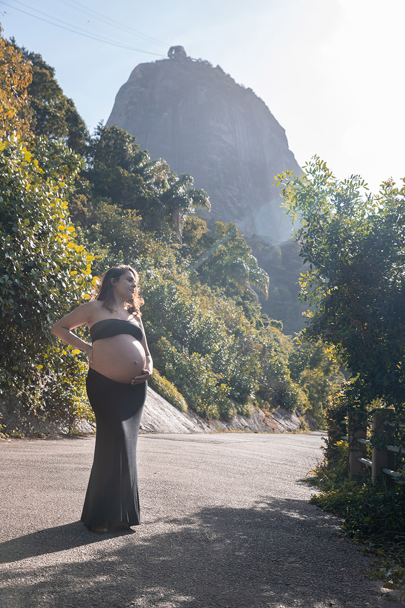 Gestante com a mào na barriga no meio de folhagens durante ensaio na Pista Claudio Coutinho, ao lado da Praia Vermelha