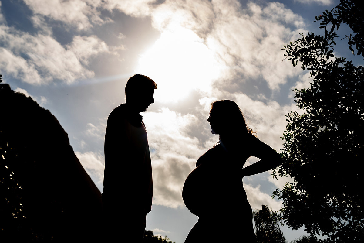 Silhueta de Casal com céu ao fundo com brilho do sol