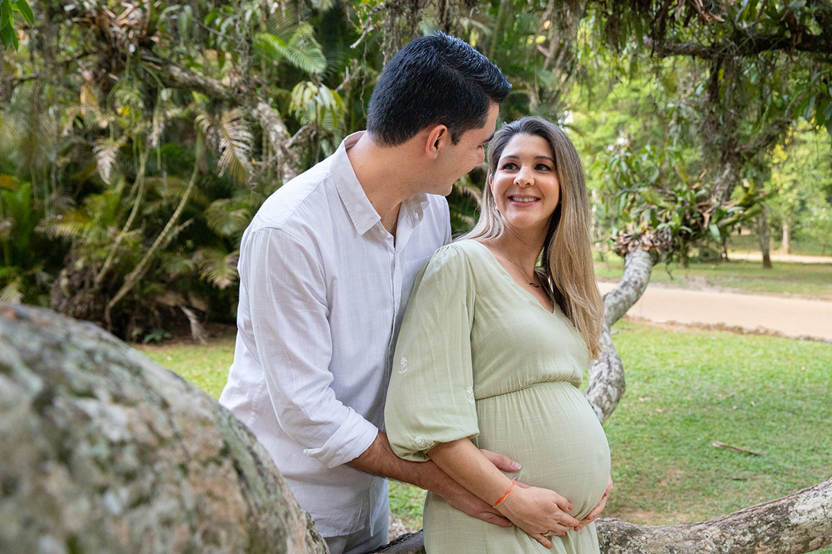 Fotografia de gestante no Rio de Janeiro em abraço carinhoso com o marido no Jardim Botânico.