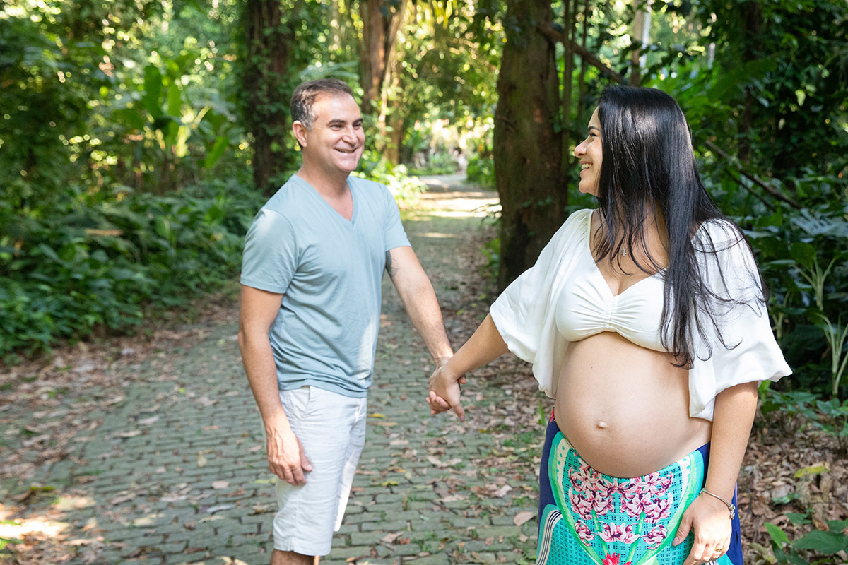 Foto de casal caminhando de mãos dadas no Parque Lage, ensaio gestante no Rio.