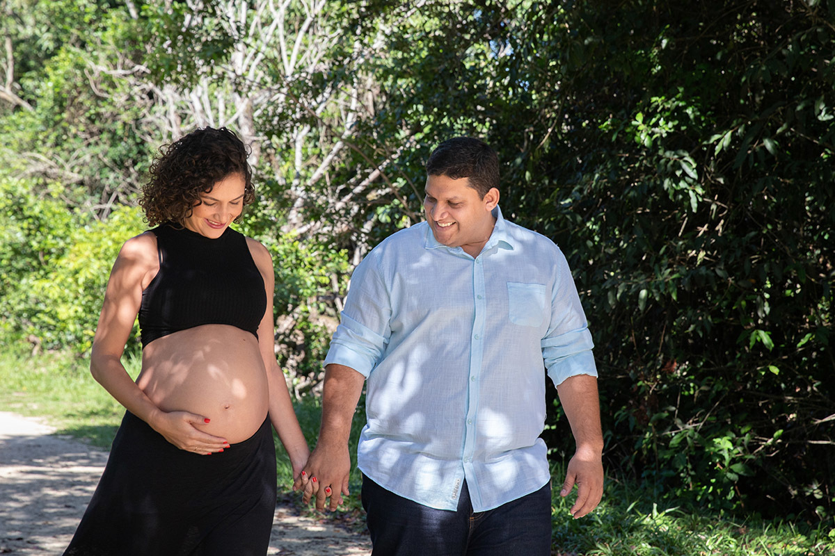 Casal caminhando entre as árvores no ensaio de gestante no Rio de Janeiro