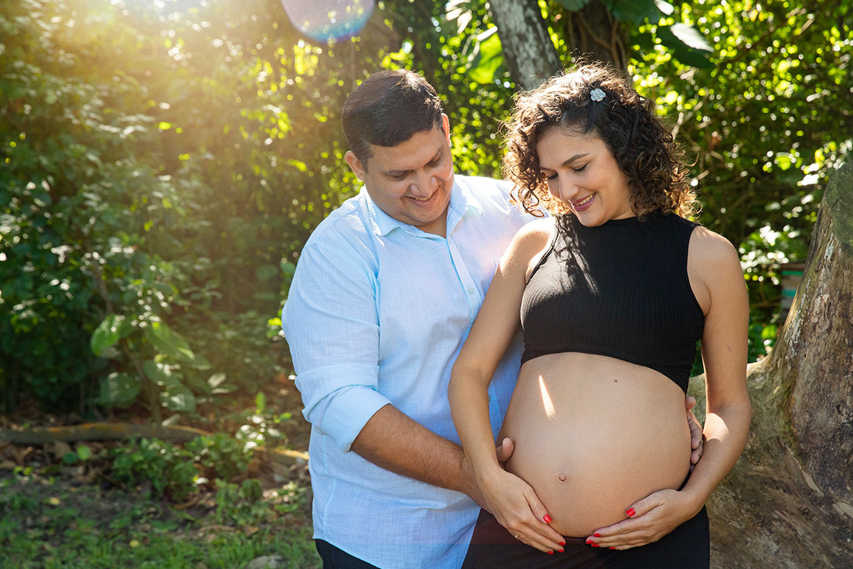 Casal sorrindo em meio ao verde no ensaio gestante no Rio de Janeiro