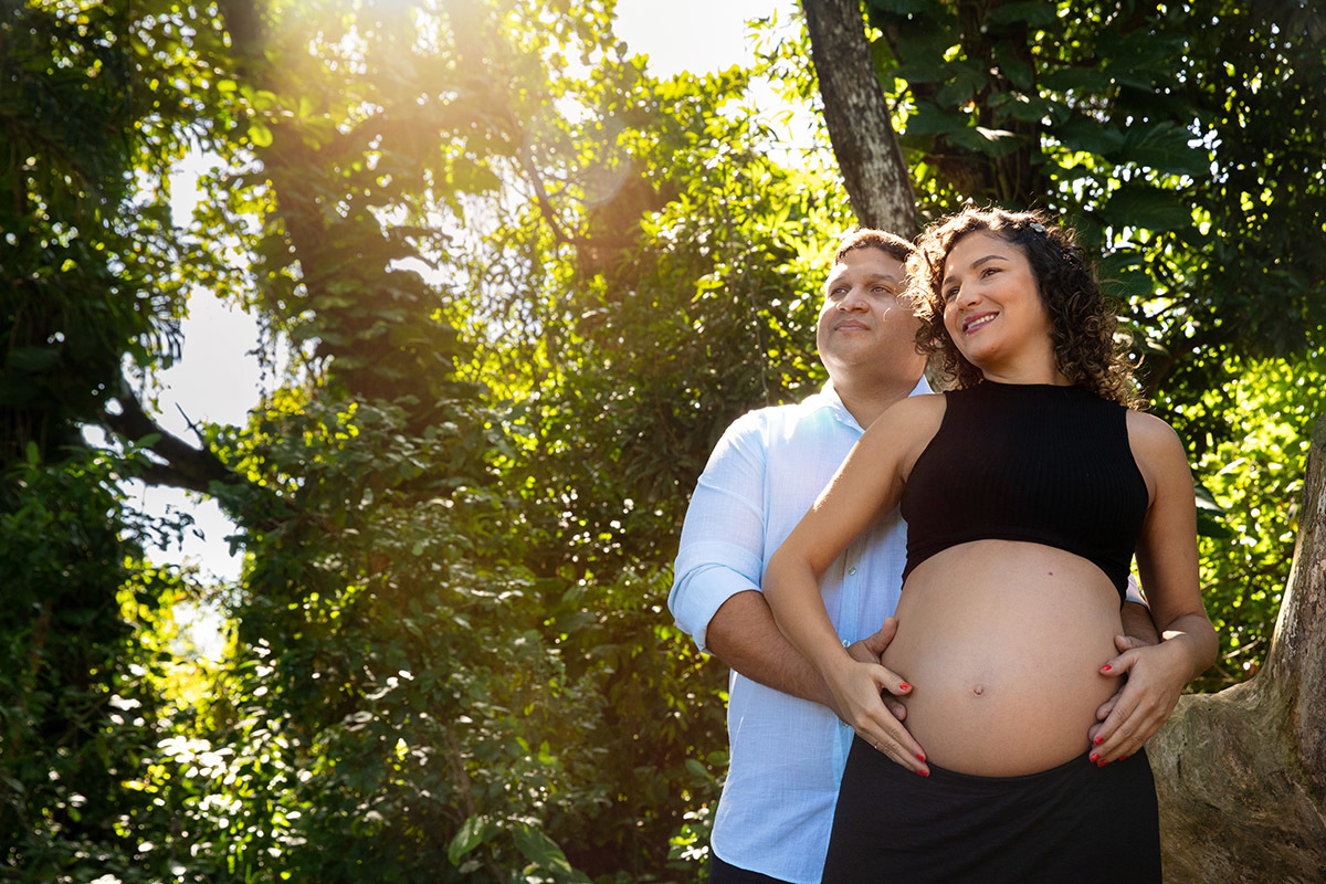 Casal abraçado com as mãos sobre a barriga no ensaio gestante no Rio