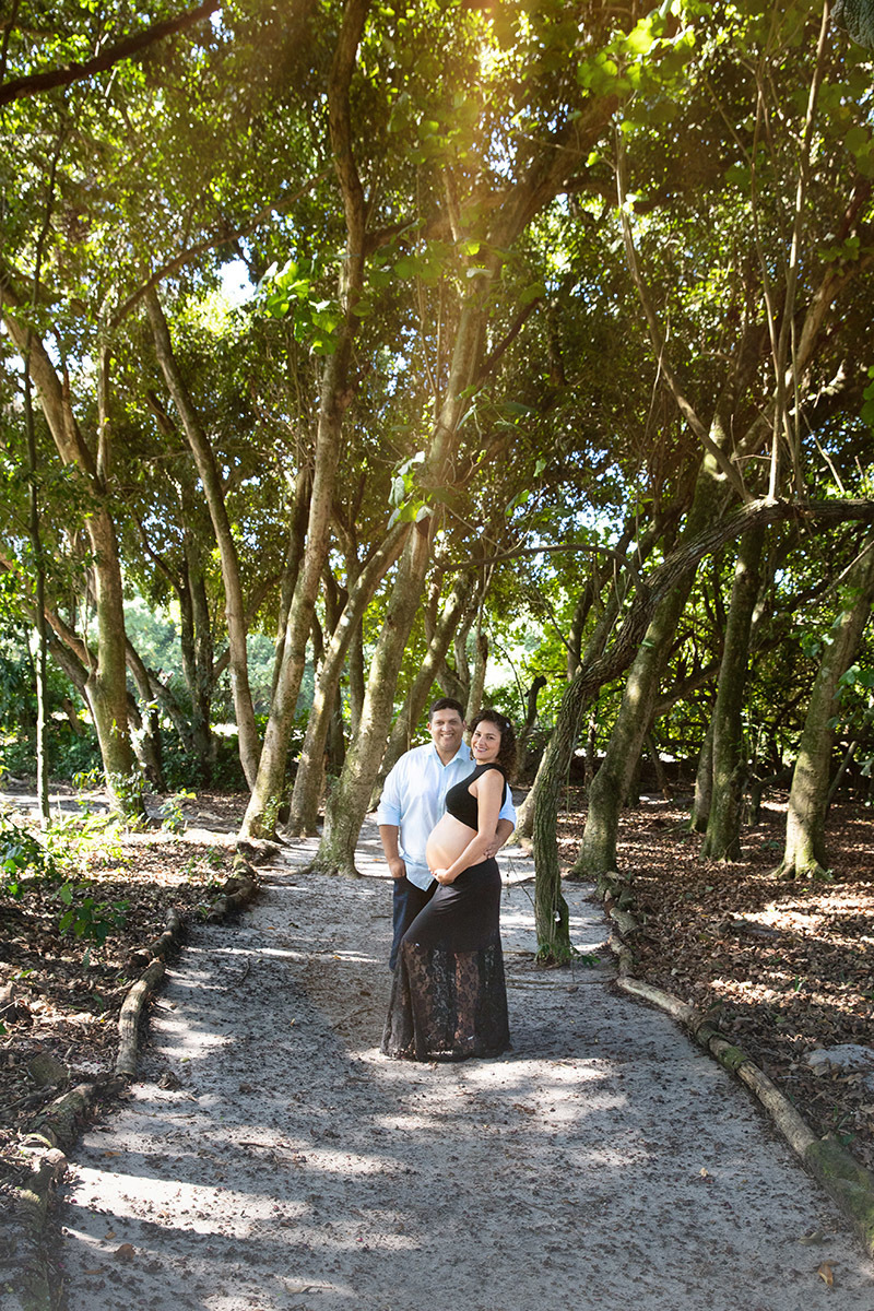 Casal sob as árvores no ensaio gestante no Rio