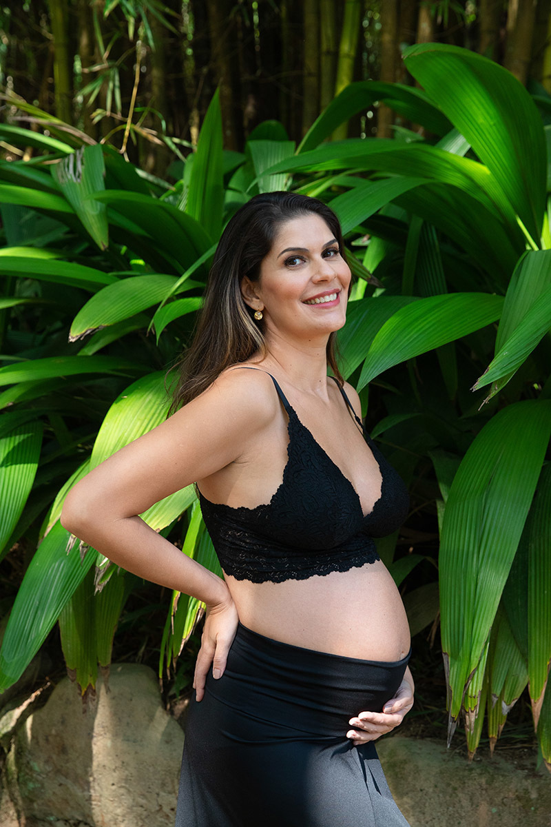 Foto artística de gestante no Jardim Botânico RJ, destacando a beleza da maternidade.Ensaio de gestante Jardim Botânico RJ, com detalhe de lingerie de renda preta.