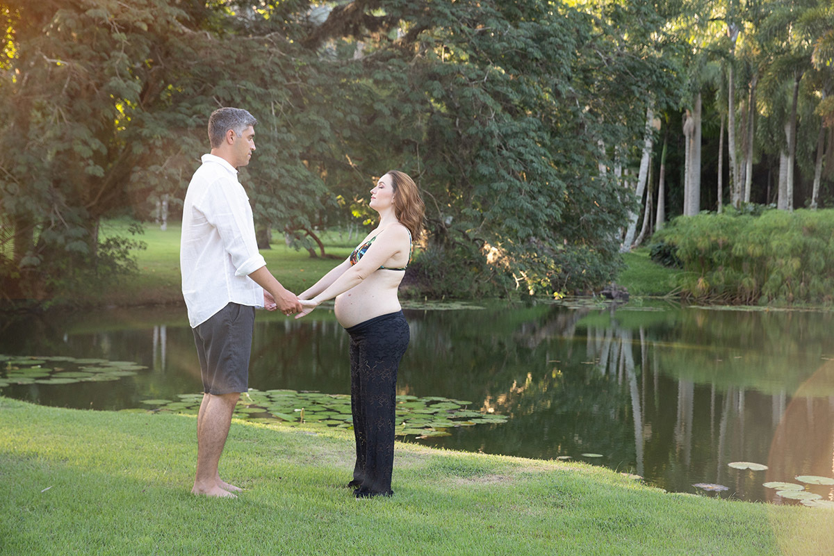 Casal sorrindo em ensaio gestante no Lago Buriti RJ.
