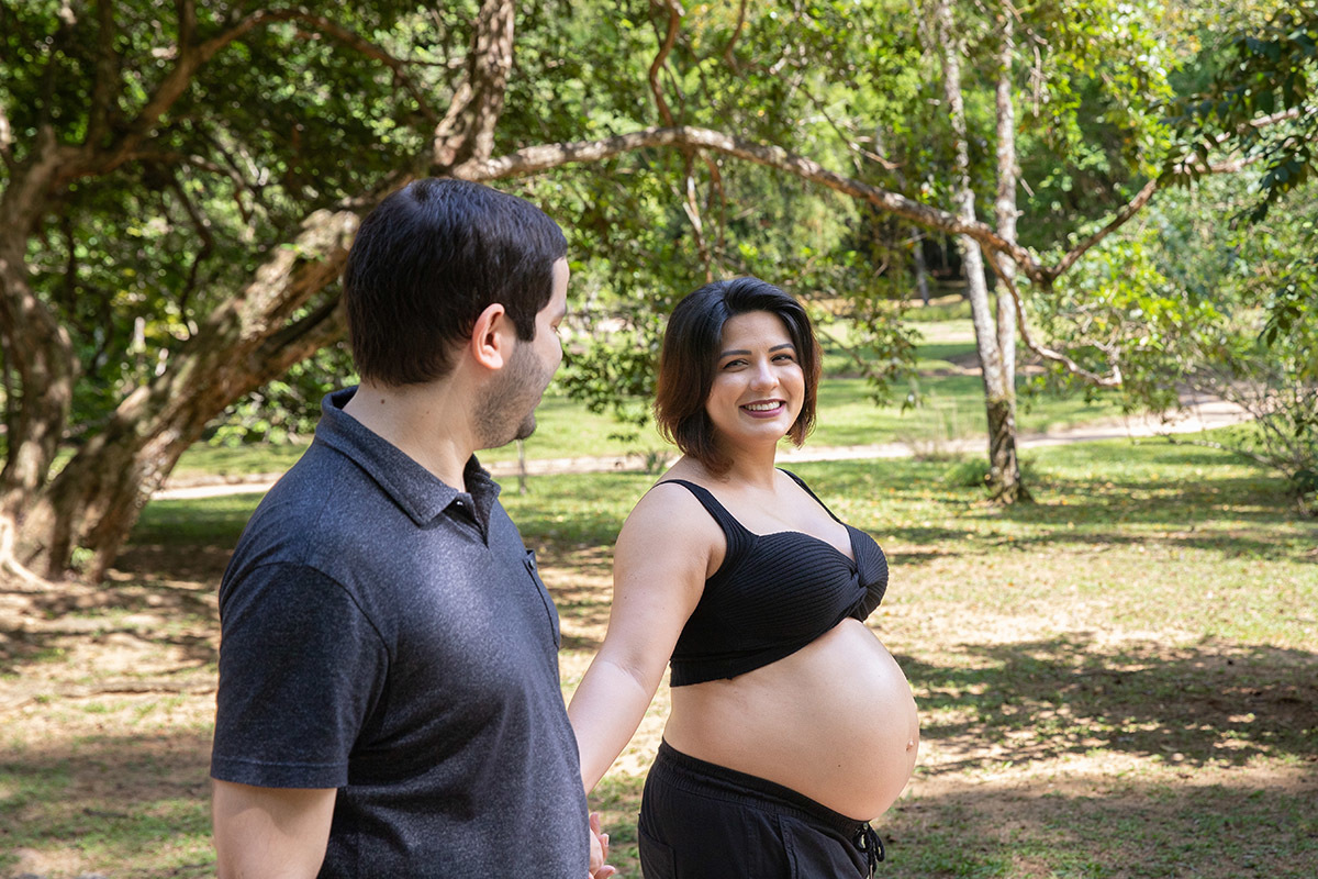 Foto de casal curtindo ensaio de gestante com cenário natural no Jardim Botânico.