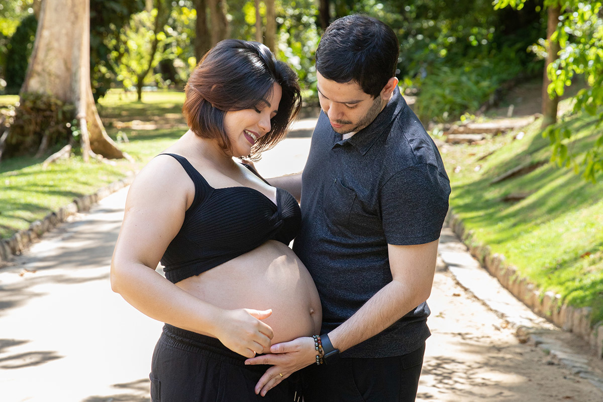 Ensaio de gestante no Jardim Botânico com casal em momento romântico.