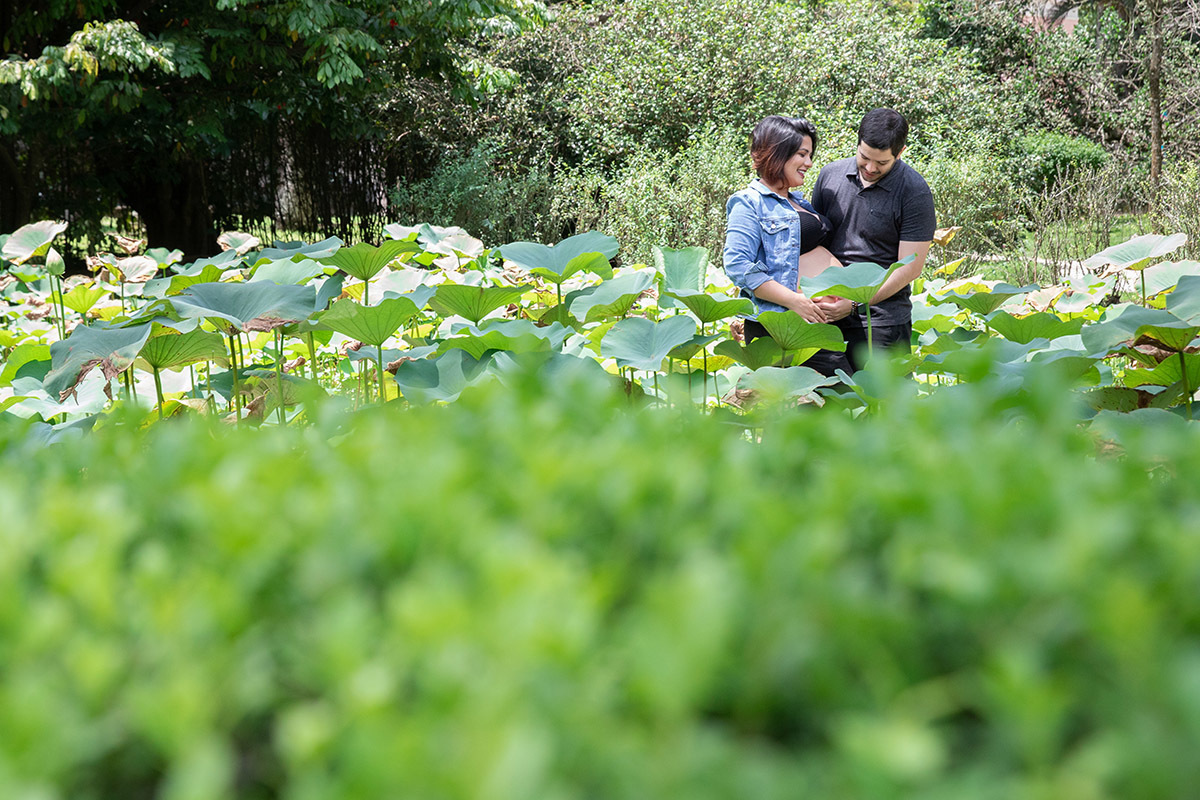 Gestante posando em meio às plantas tropicais no Jardim Botânico.