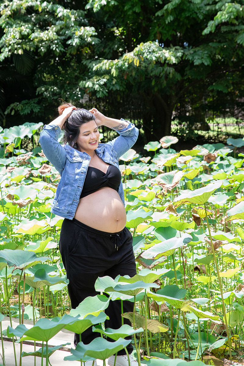 Gestante posando em meio às plantas tropicais no Jardim Botânico.