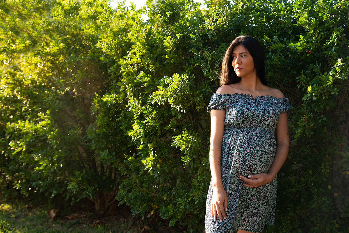 Gestante em ensaio no Parque Lage RJ cercada pela natureza verde.