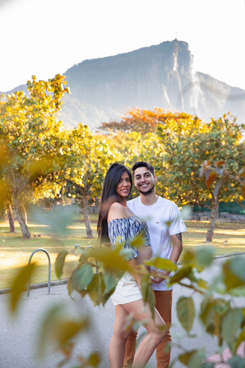 Casal em ensaio de gestante na Lagoa com cenário dourado de fim de tarde.