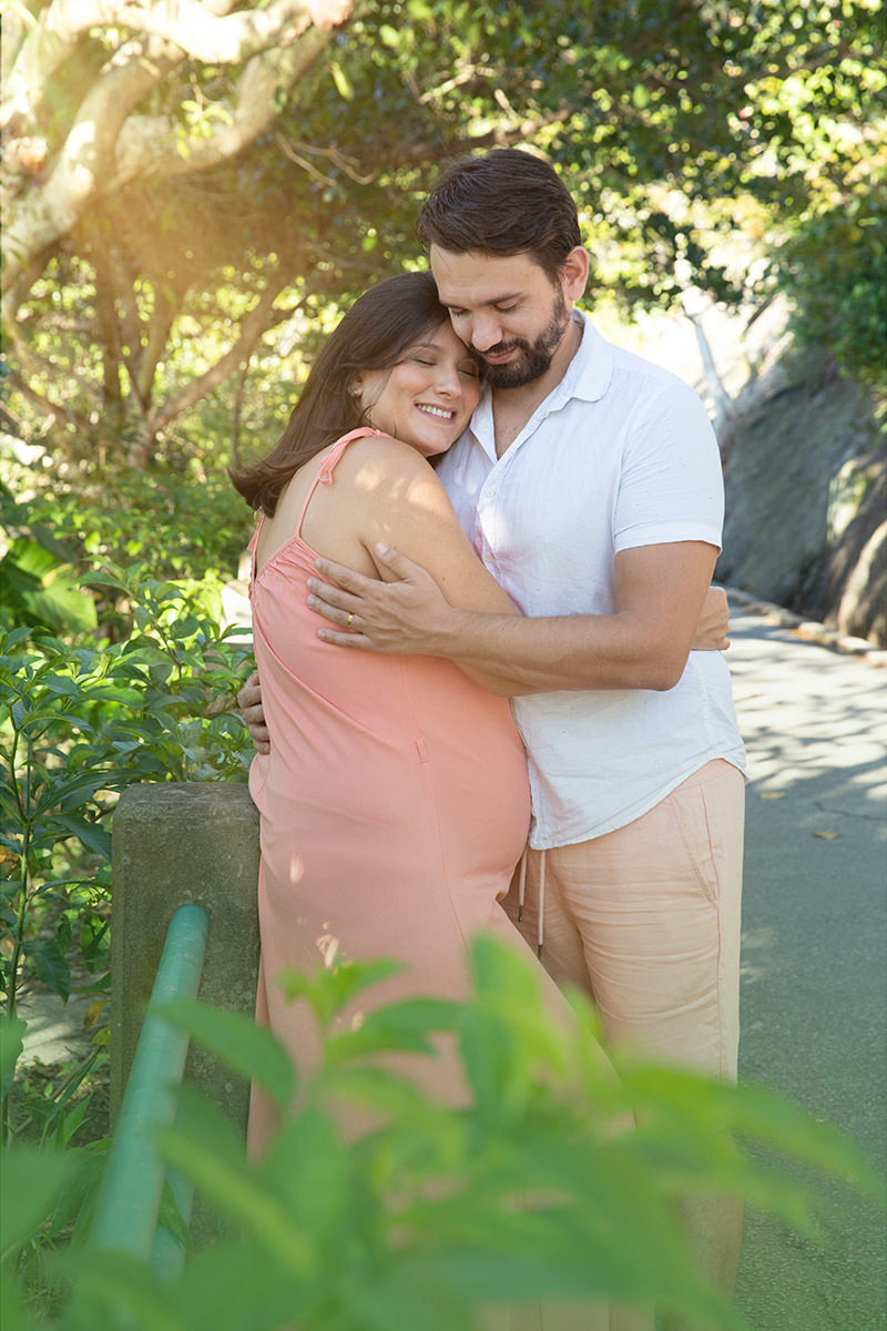 Casal abraçado em ensaio gestante na Praia Vermelha, Rio de Janeiro.